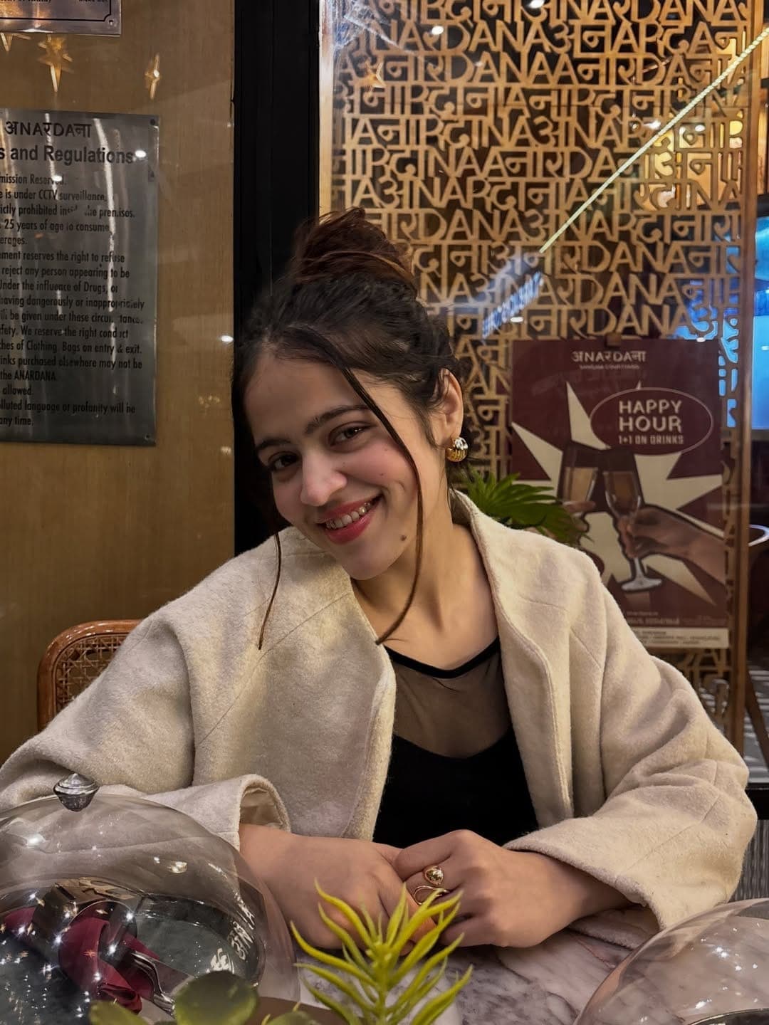 Priya smiling at a café table